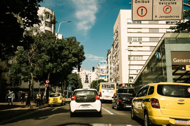 Capture of a lively street in Rio de Janeiro, featuring traffic and pedestrians on a sunny day.